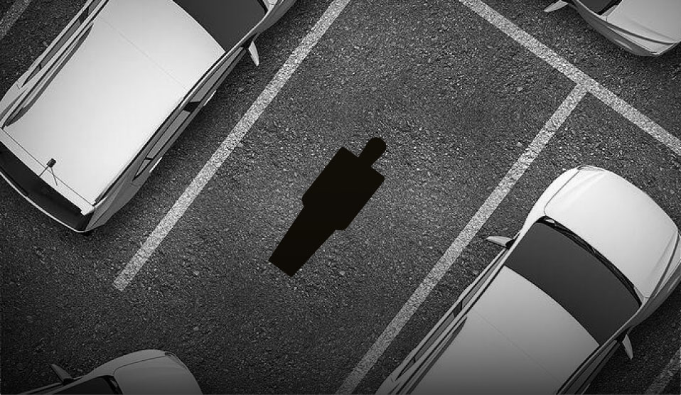 An illustration of a parking space viewed from overhead, with a silhouette of a human being superimposed within the parking space to show scale.